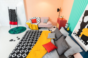 Living room interior in modern apartment with colorful furniture and textile, black and white...