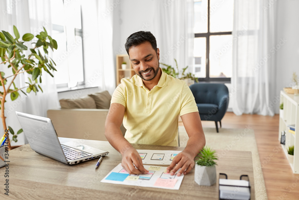 Poster business, remote job and technology concept - happy smiling indian man or ui designer with laptop co