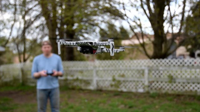 Man Controlling A Drone Flying In The Garden - closeup shot