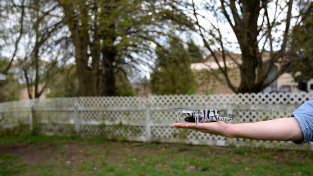 Drone Descending To A Man's Hand In The Garden - slowmo