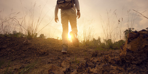 Man hiker adventure to overcome limit of life on the trail at sunset mountains with  backpack. © ME Image