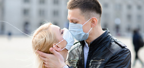Young couple in love in protective medical mask on face outdoor at street. Environmental pollution concept. Guy and girl in virus protection