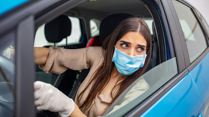 Woman driving car while wearing protective mask. Young woman protect her self from Corona virus wearing protective mask. Adult Woman Driving to Work Wearing Face Mask and Surgical Gloves