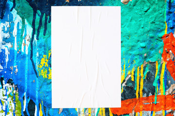 Closeup of colorful messy painted urban wall texture with wrinkled glued poster template . Modern mockup for design presentation. Creative urban city background. 