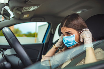 A young woman is putting a mask on her face, to avoid infection during flu virus outbreak and coronavirus epidemic, getting ready to go to work by car. Healthcare, virus protection