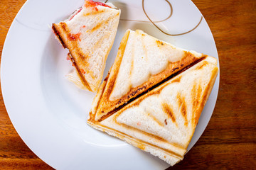top view bitten sandwiches are placed in a dish that has messed up the bread crumbs on wooden table