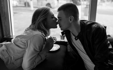 Surprise! Beautiful romantic couple in cafe. Young man is coming of the date to his beloved in...