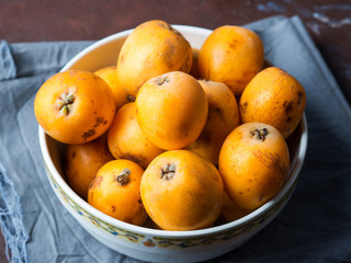 Loquat Japanese medlar fruit in bowl on dark background