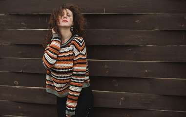 Autumn fashionable ideas. Woman in knitted black orange sweater. Modern fashion