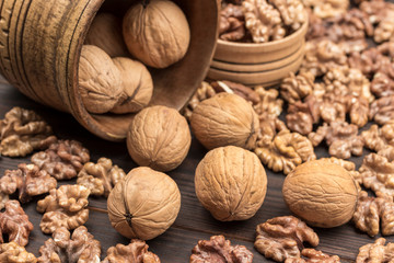 Walnut kernels, whole walnuts, nuts in bowl.