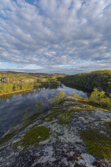 The reservoir is surrounded by hills and forest.Clouds are reflected in the water.Summer landscape.