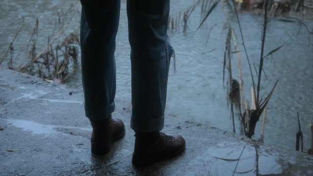 Pies de persona con botas delante de la lluvia