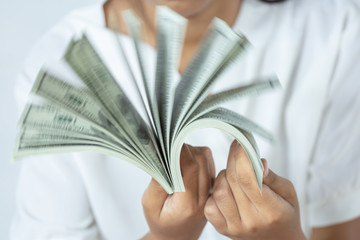 US dollars. Hand counting one hundred american money or 100 USD domination note.