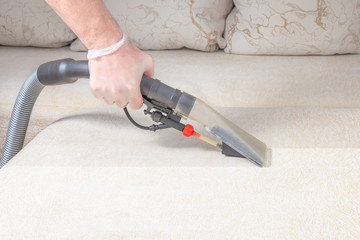 cleaning the sofa with a vacuum cleaner in the time of dangerous viruses with professional equipment