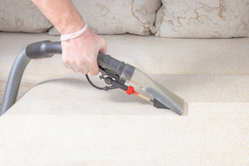 cleaning the sofa with a vacuum cleaner in the time of dangerous viruses with professional equipment © Celt Studio