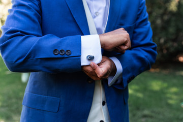 Stylish groom with cufflinks outdoors. concept of marriage and love