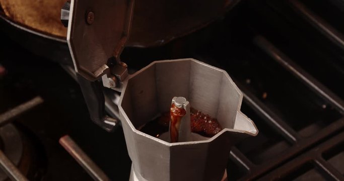 percolator moka pot bubbling and brewing coffee on a gas stove top