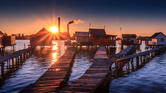 Sunset fishing houses on a lake in Bokod