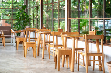 Empty wood table with artificial plant decoration on the wall of coffee shop ecology design interior