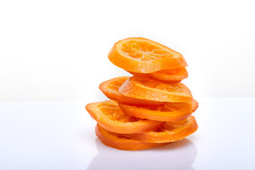 Fototapeta na wymiar Slices Dried oranges or tangerines isolated on a white background. Vegetarianism and healthy eating