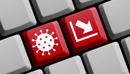 Coronavirus Symbol und sinkender Pfeil auf Computer Tastatur