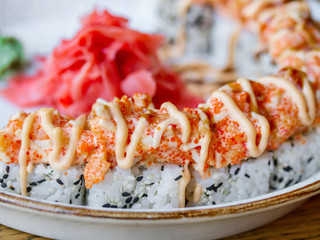 Japanese style rolls with sesame seeds and flying fish caviar close-up