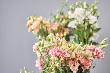 Obraz premium Bouquet of Beautiful pink, white, green color eustoma in vase . Spring flowers in the cold room of the flower shop.