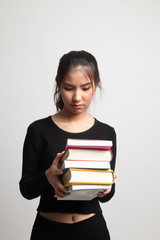 Unhappy young Asian woman studying  with may books.