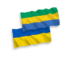 National vector fabric wave flags of Gabon and Ukraine isolated on white background. 1 to 2 proportion.