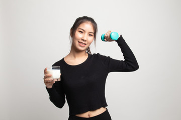 Healthy Asian woman drinking a glass of milk and dumbbell.