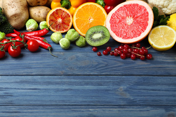 Fresh products rich in vitamin C on blue wooden table. Space for text