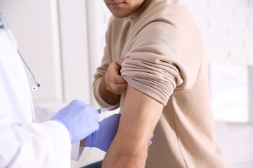 Obraz premium Doctor giving injection to patient in hospital, closeup. Vaccination concept