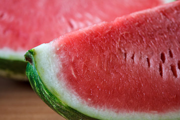 Close-up of a sliced quarter of ripe watermelon with juicy pink red pulp