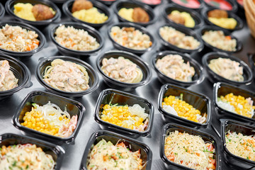 Food delivery. Different in plastic disposable lunch box with healthy natural food. Chicken broth, mashed soup, mashed potatoes with cutlet, seafood pasta, salads, pilaf with a fresh bun.