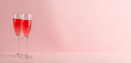 Two glasses of red sparkling wine on pink background