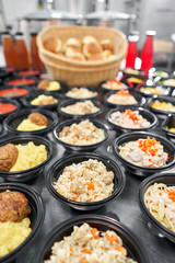 Food delivery. Different in plastic disposable lunch box with healthy natural food. Chicken broth, mashed soup, mashed potatoes with cutlet, seafood pasta, salads, pilaf with a fresh bun.