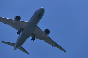 青空の下着陸態勢の飛行機
