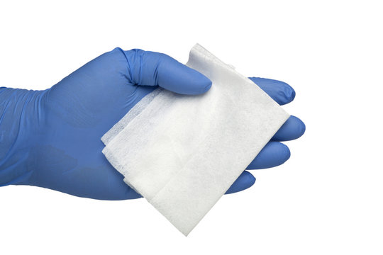 Gloved hand holding an antibacterial cleansing wipe