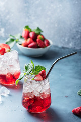 Red cocktail with ice and fresh strawberry