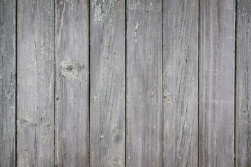 Part of an old fence of painted wooden boards on the street. Old wooden fence made of flat boards. Faded texture with peeling paint. Copy space