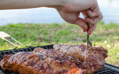 Cooking steak on the grill in nature on a background of water