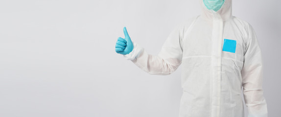 male model in PPE suite and face mask doing thumbs up  hand sign on white background.
