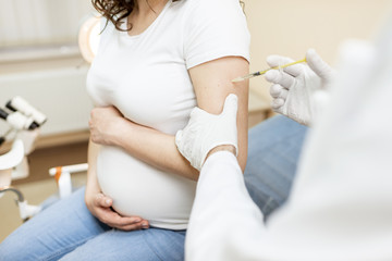 Vaccine injection procedure for a pregnant woman, cropped view without face