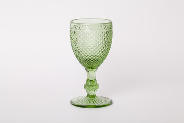 one empty glass of green glass on a stem on a white background
