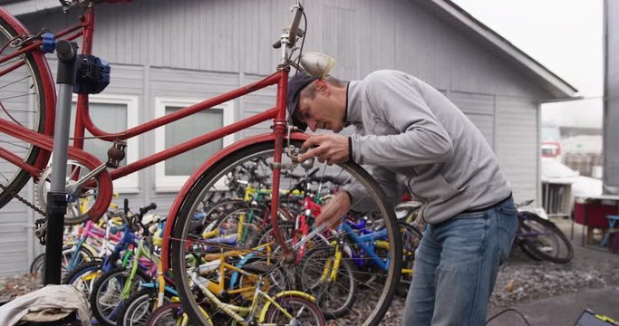 4K Medium Shot Of Man Fixing Bicycle Tyre To Be Reused