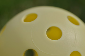 Five holes in yellow floorball ball