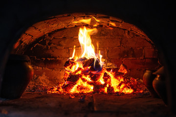 Village stove firewood and fire. Burning wood inside traditional oven