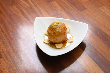 fried ice cream garnished with banana and honey on a serving plate