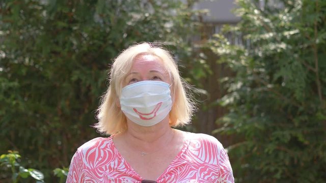 Senior Woman standing in face mask during pandemic time in 4K Slow motion 60fps