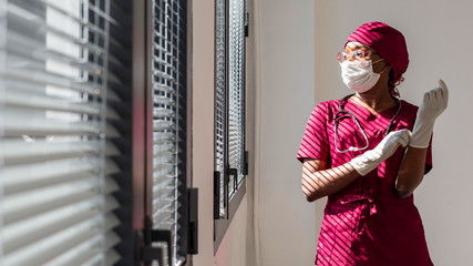 Female doctor putting her gloves. Black health professional, afro american doctor, african nurse.